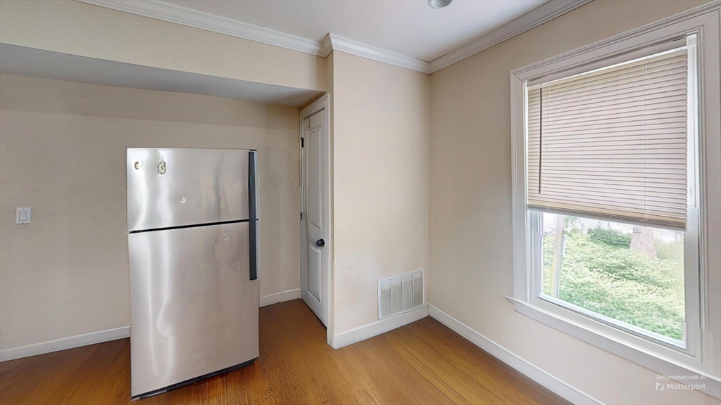 2971 Washington Street, Unit 1 Boston, MA 02119 - Photo 2 of 7 a view of a room with wooden floor and a refrigerator