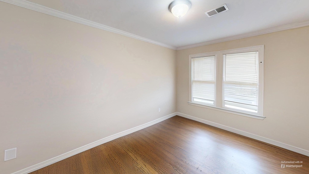 2971 Washington Street, Unit 1 Boston, MA 02119 - Photo 4 of 7 an empty room with wooden floor and windows