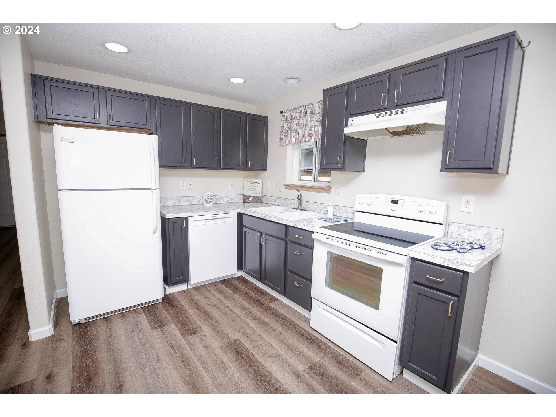4112 South E Street Springfield, OR 97478 - Photo 9 of 21 a kitchen with a sink a stove a refrigerator and a microwave