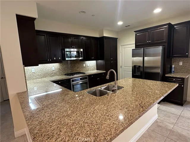 a kitchen with stainless steel appliances granite countertop a refrigerator and a sink
