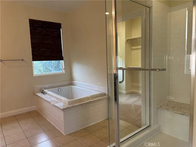 a bathroom with a bathtub a shower and mirror