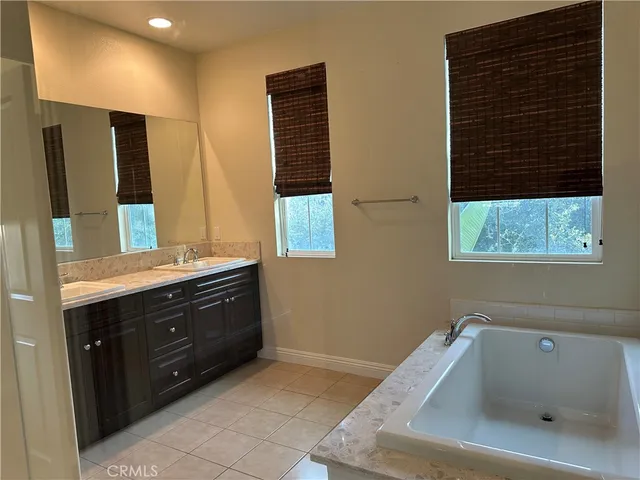 a bathroom with a bathtub sink and mirror