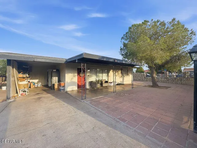a view of a house with sitting area and large tree