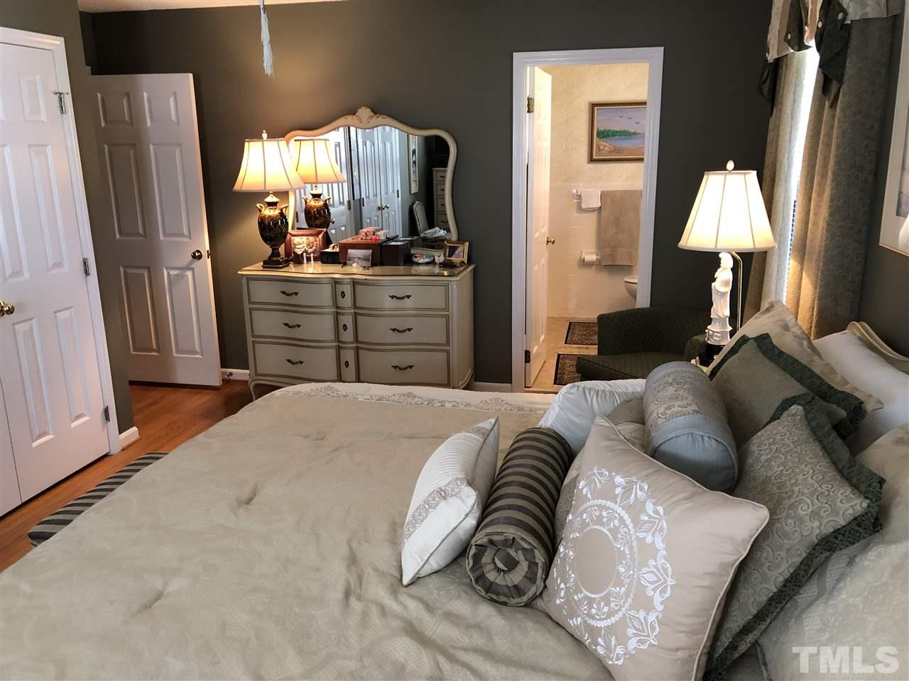 3907 Converse Drive Raleigh, NC 27609 - Photo 17 of 30 a spacious bedroom with a bed a dresser and a flat tv screen