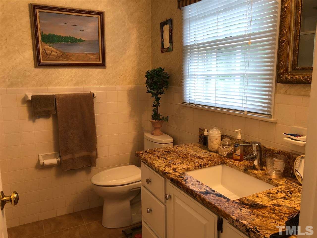 3907 Converse Drive Raleigh, NC 27609 - Photo 18 of 30 a bathroom with a granite countertop sink toilet and a shower
