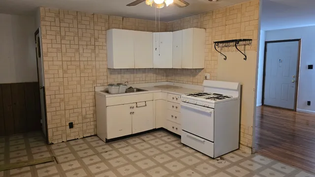 a kitchen with a stove cabinets and wooden floor