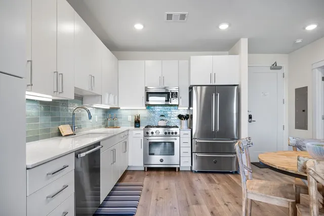 a kitchen with kitchen island granite countertop stainless steel appliances and wooden cabinets