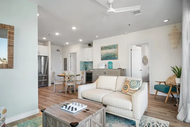 a living room with furniture and a dining table with kitchen view