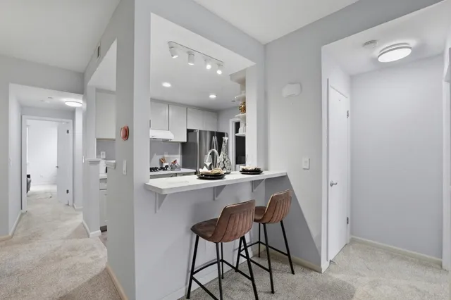 a kitchen with kitchen island wooden cabinets and refrigerator