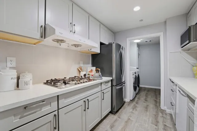 a kitchen with cabinets and stainless steel appliances