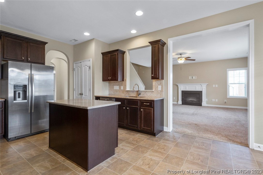 152 Copper Loop Sanford, NC 27332 - Photo 25 of 50 a large kitchen with kitchen island granite countertop a refrigerator and a stove top oven