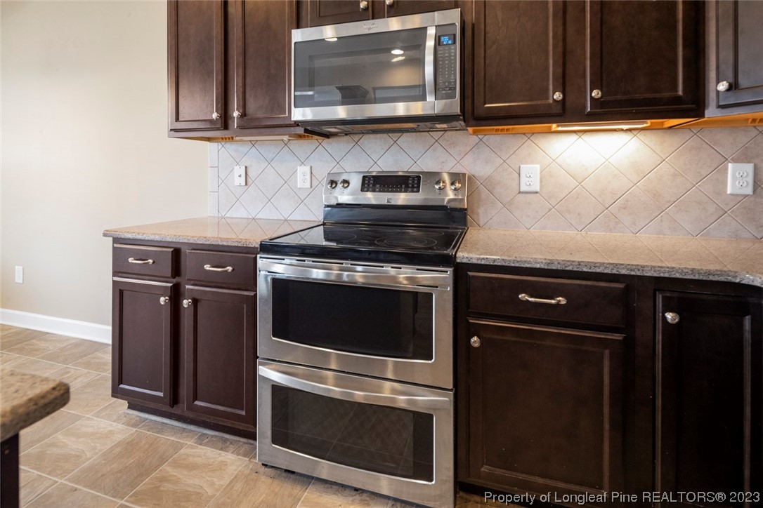 152 Copper Loop Sanford, NC 27332 - Photo 27 of 50 a kitchen with granite countertop a stove microwave and sink