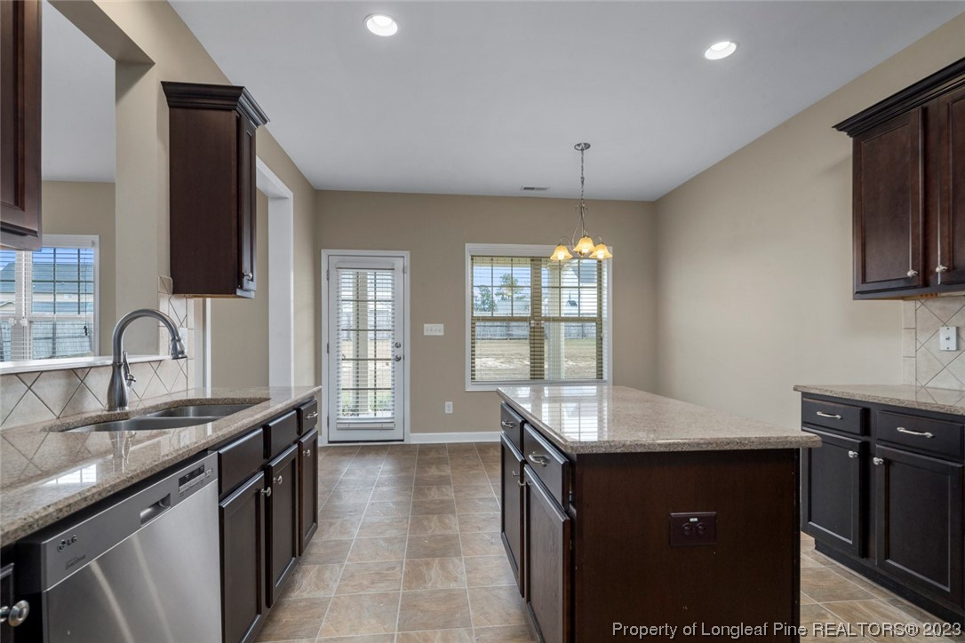 152 Copper Loop Sanford, NC 27332 - Photo 29 of 50 a kitchen with granite countertop a sink stove and cabinets