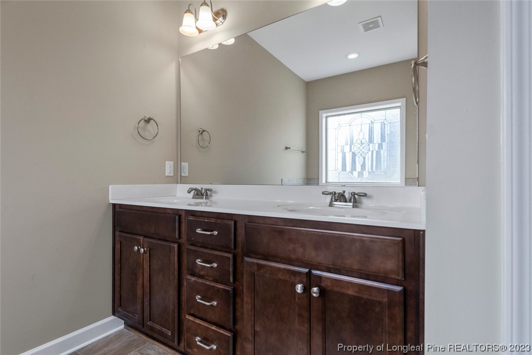 152 Copper Loop Sanford, NC 27332 - Photo 34 of 50 a bathroom with a sink vanity and a mirror