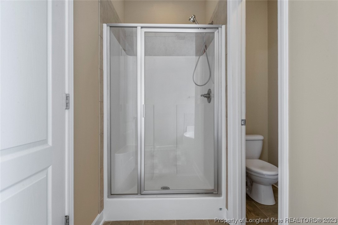 152 Copper Loop Sanford, NC 27332 - Photo 35 of 50 a bathroom with a glass shower door