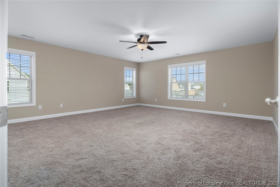 152 Copper Loop Sanford, NC 27332 - Photo 37 of 50 an empty room with windows and ceiling fan
