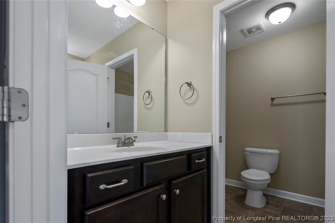 152 Copper Loop Sanford, NC 27332 - Photo 42 of 50 a bathroom with a granite countertop toilet sink and mirror