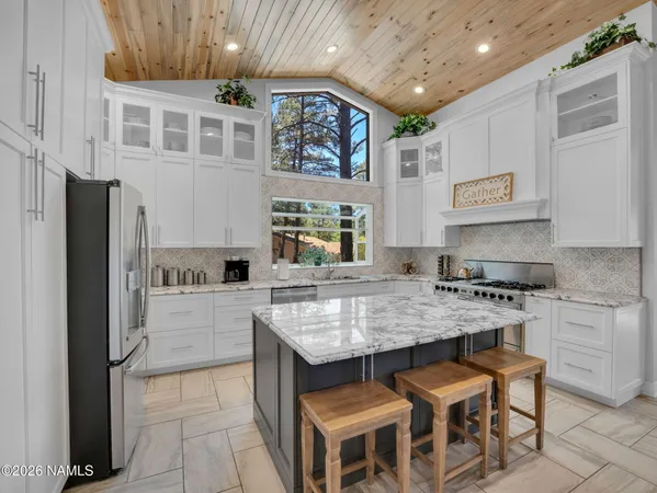 a kitchen with stainless steel appliances granite countertop a stove sink and cabinets