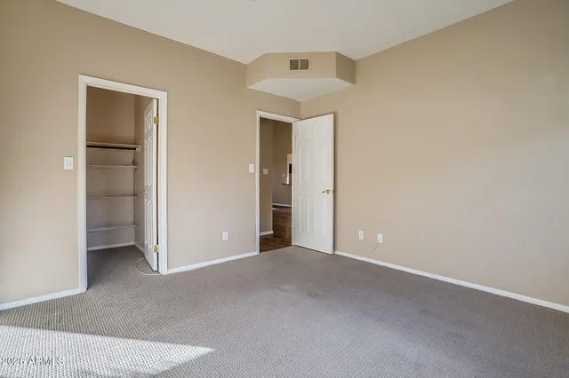 an empty room with closet and a hallway