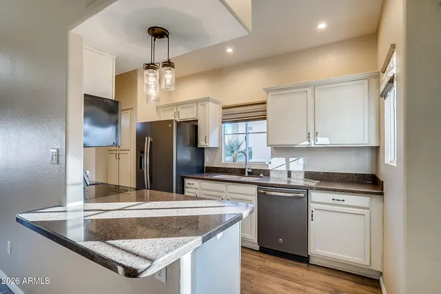 a kitchen with stainless steel appliances granite countertop a sink a stove and refrigerator