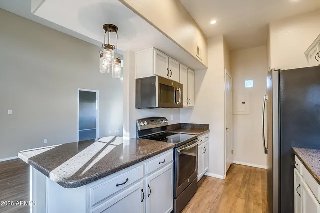 a kitchen with granite countertop stainless steel appliances a sink stove and refrigerator