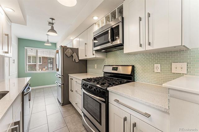 a kitchen with stainless steel appliances granite countertop a stove and a microwave
