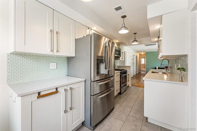 a kitchen with refrigerator and cabinets