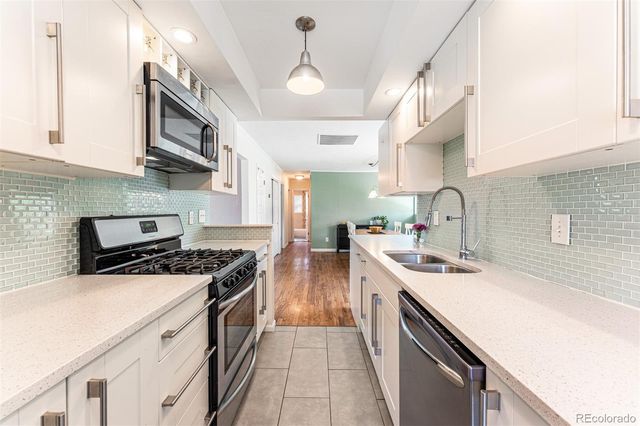 a kitchen with stainless steel appliances a sink stove and cabinets
