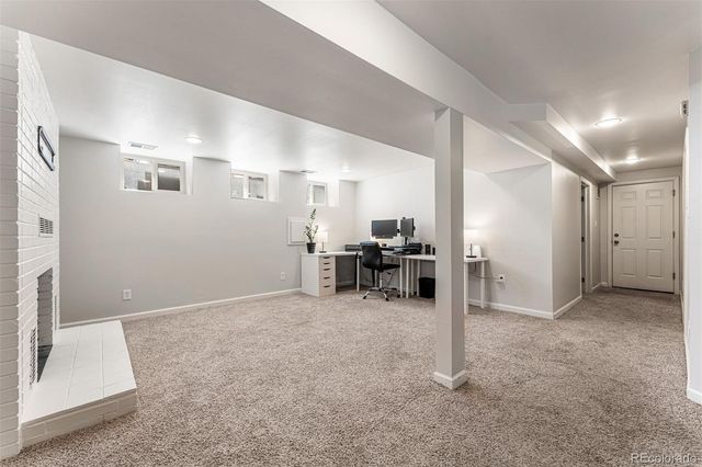 a view of a livingroom with furniture and a refrigerator