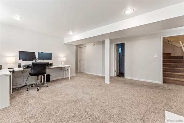 a view of a workspace with furniture and a window