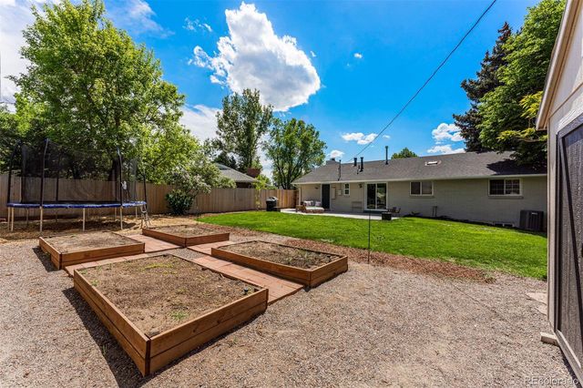 a view of a house with a yard and large tree