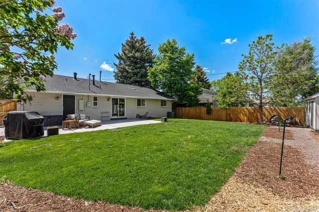a front view of house with a garden and trees