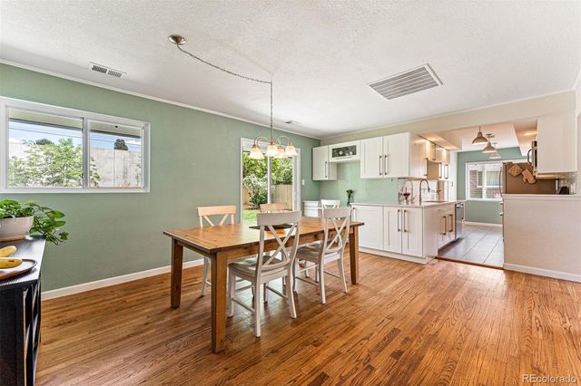 a kitchen with stainless steel appliances wooden floors and table