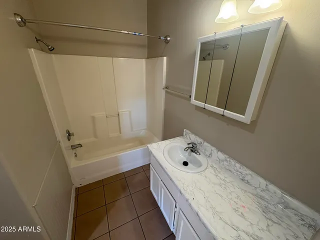 a bathroom with a tub sink and mirror