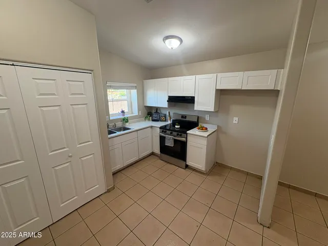 a kitchen with white cabinets a sink and appliances