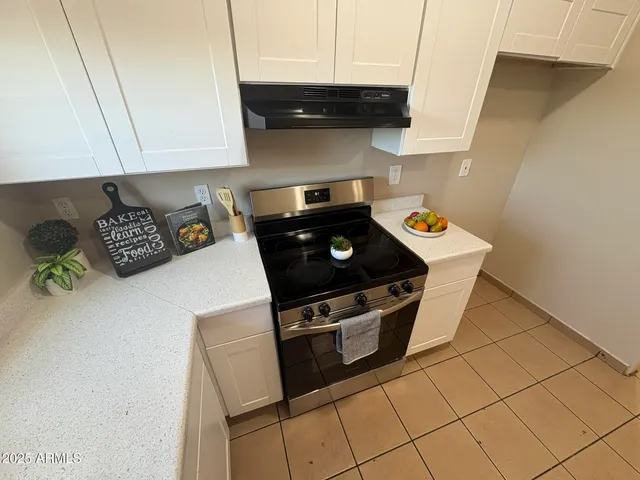 a kitchen with granite countertop a stove a microwave and cabinets