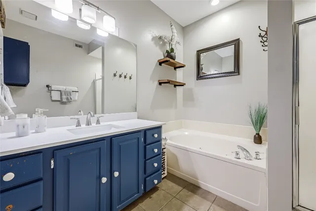 a bathroom with a tub a sink and mirror