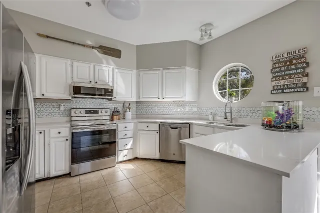 a kitchen with stainless steel appliances a stove sink and microwave