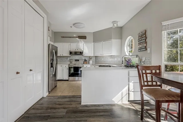 a kitchen with kitchen island wooden cabinets and stainless steel appliances