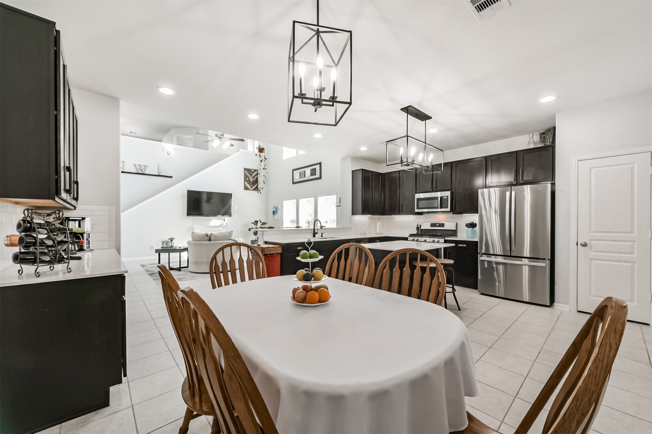 10018 Chase Court Baytown, TX 77521 - Photo 18 of 50 a kitchen with stainless steel appliances a dining table chairs refrigerator and sink