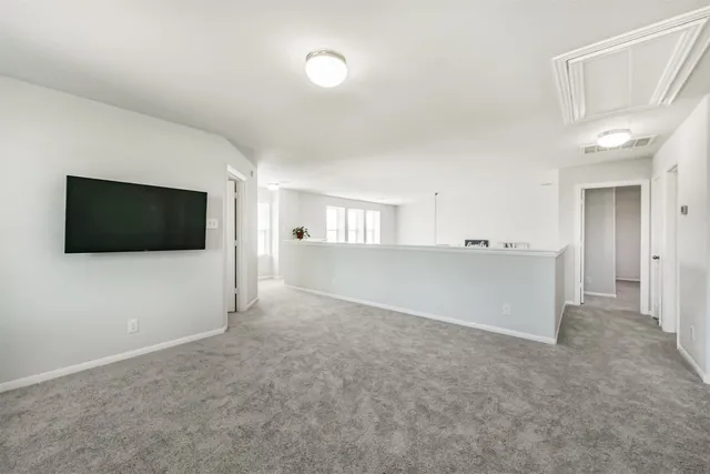 a view of a livingroom with an empty space and a kitchen