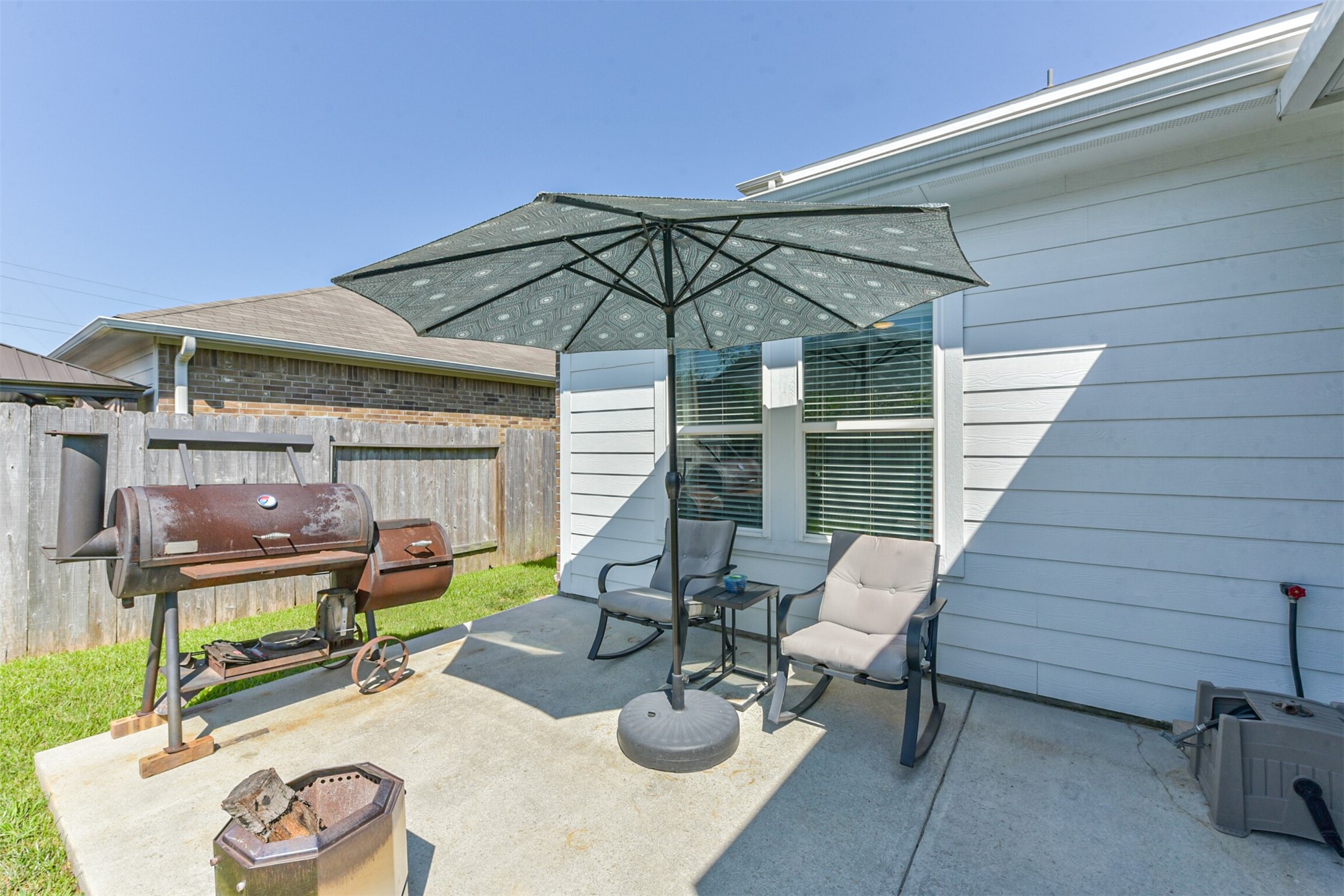 10018 Chase Court Baytown, TX 77521 - Photo 37 of 50 a view of a patio with couches table and chairs under an umbrella