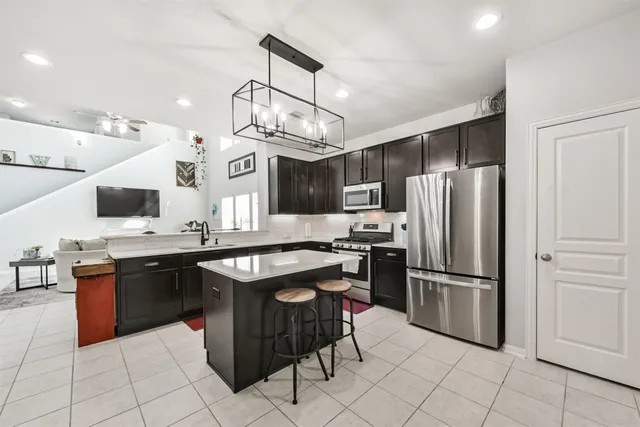 a kitchen with stainless steel appliances granite countertop a sink and a refrigerator
