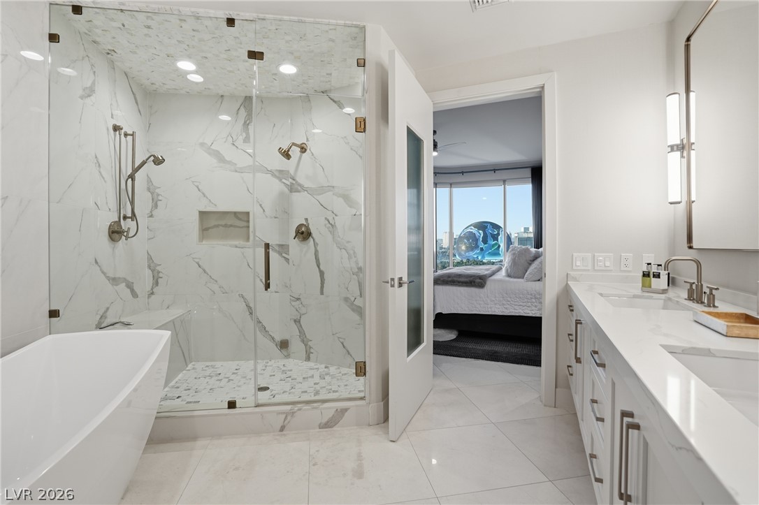 360 East Desert Inn Road, Unit 1701 Las Vegas, NV 89109 - Photo 21 of 33 A well-appointed primary bathroom showcases a freestanding tub and a glass-enclosed shower.