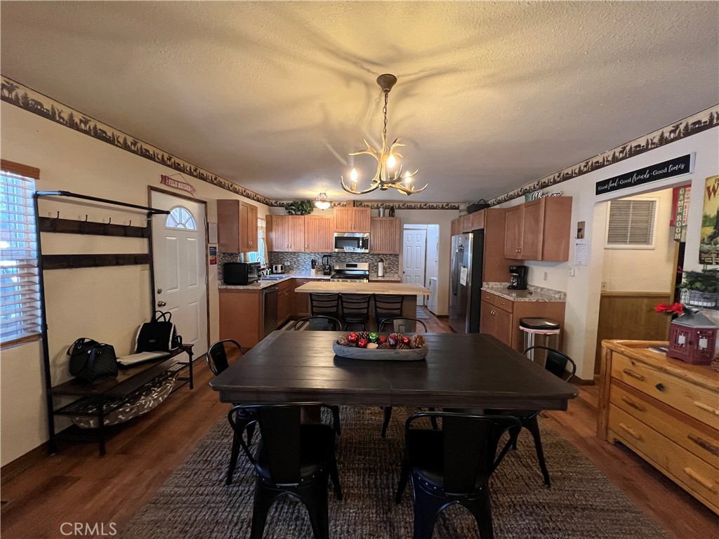 39307 Lark Road Big Bear Lake, CA 92315 - Photo 15 of 35 a kitchen with a dining table chairs and refrigerator