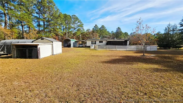 a front view of a house with a yard and trees