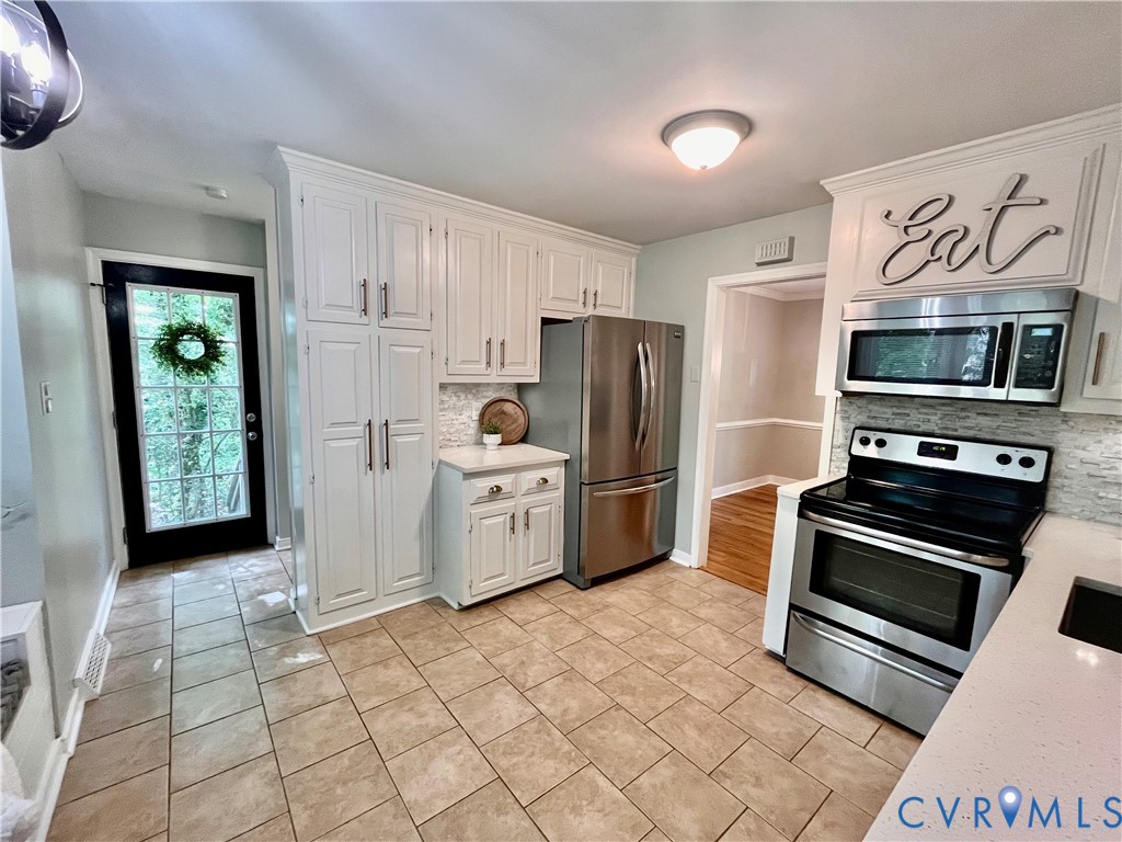 13700 Watkins Glen Road Midlothian, VA 23112 - Photo 6 of 23 a kitchen with stainless steel appliances a refrigerator a stove a microwave and cabinets