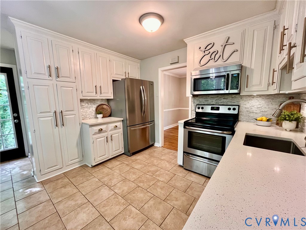 13700 Watkins Glen Road Midlothian, VA 23112 - Photo 7 of 23 a kitchen with white cabinets and stainless steel appliances