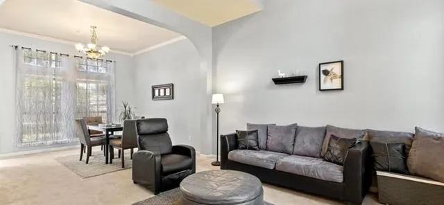 a living room with furniture and a chandelier