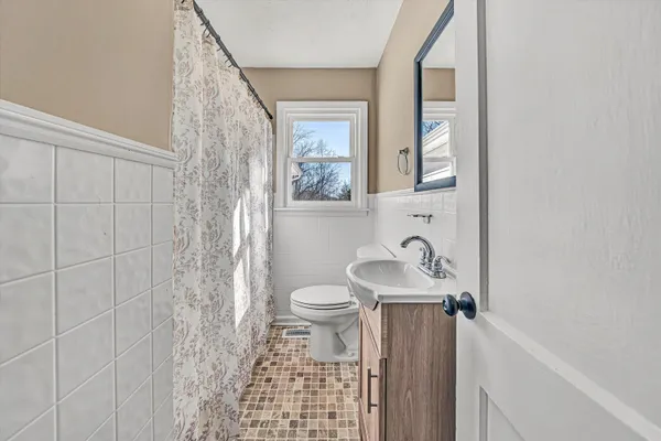 a view of an empty room with window and bathroom